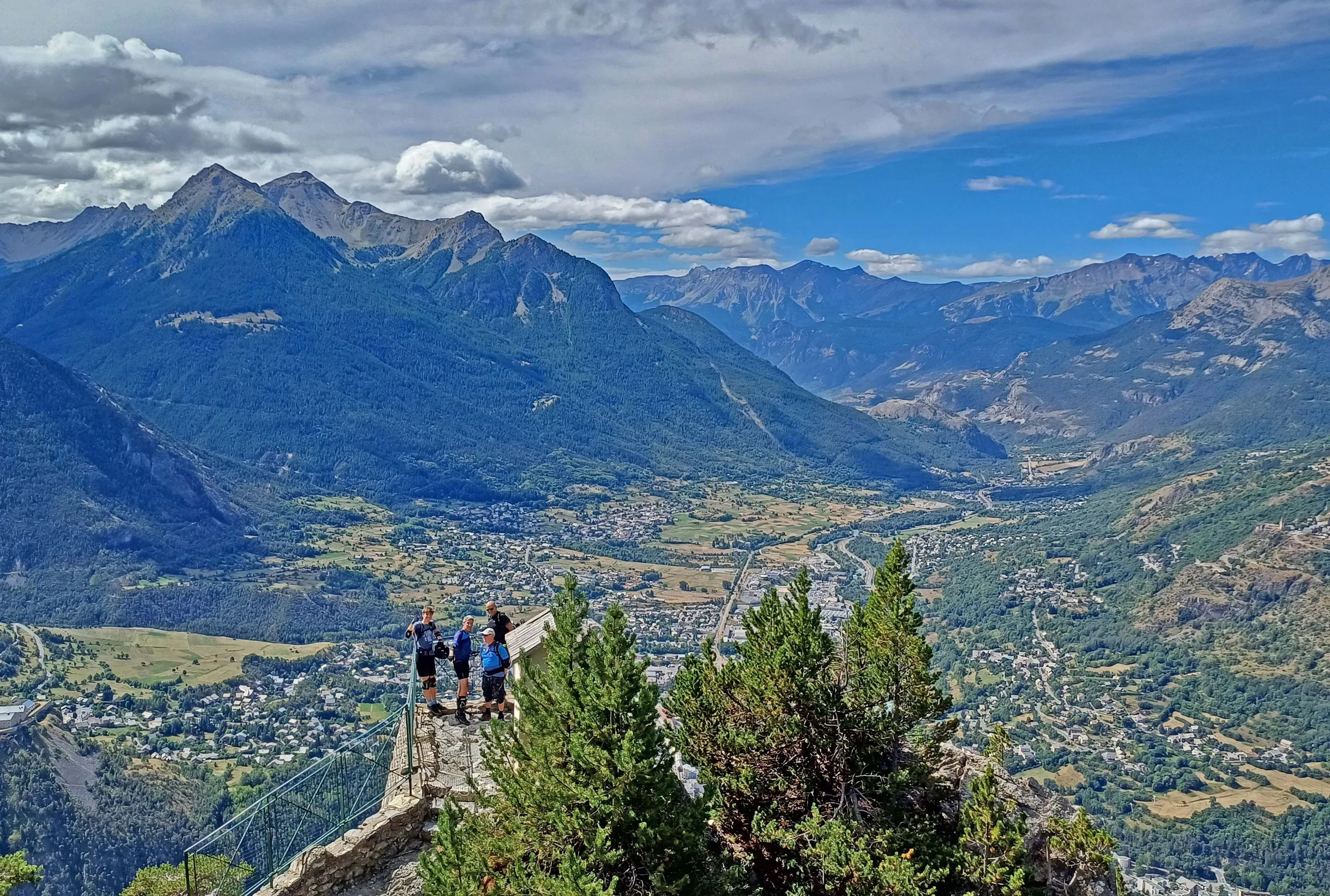 Mountain bikers stopping at a viewpoint over the Briançon valley